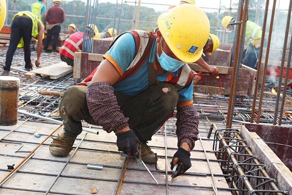 广州医科大学附属妇女儿童医院一期工程施工现场,工人正在绑扎钢筋.